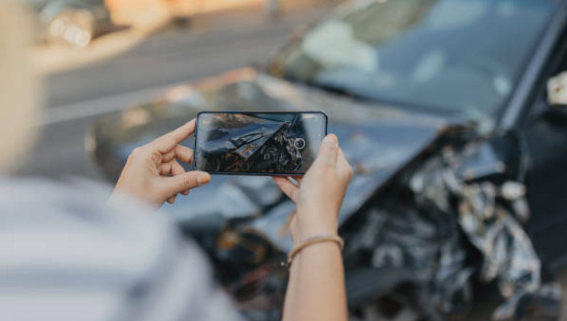 persona tomando una fotografia de un accidente de trafico